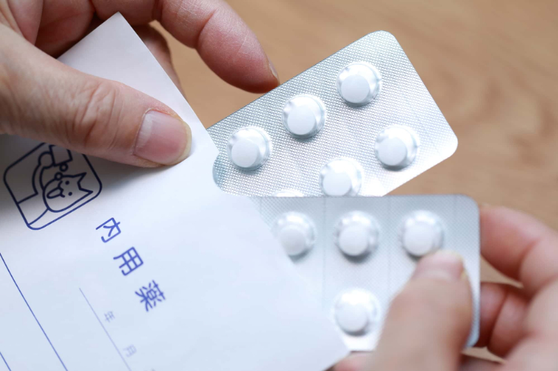 根管治療後の痛みを和らげるために鎮痛剤を飲むイメージ