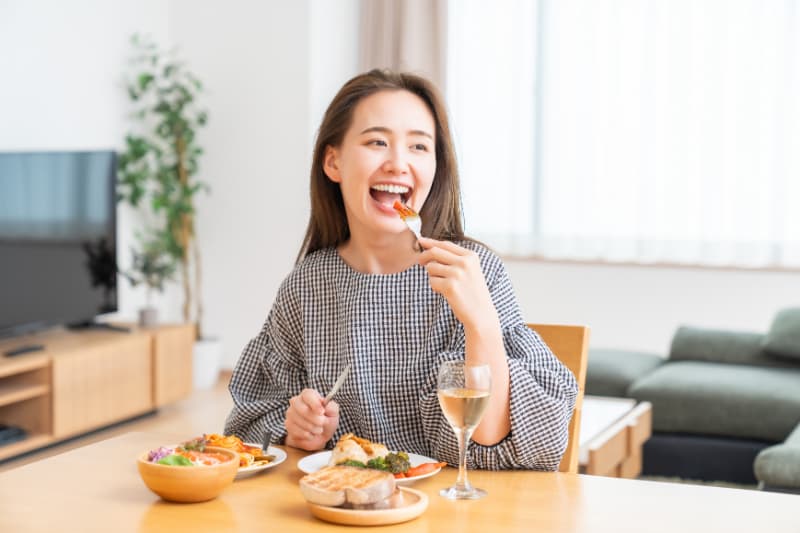 美味しそうに食事を楽しむ女性
