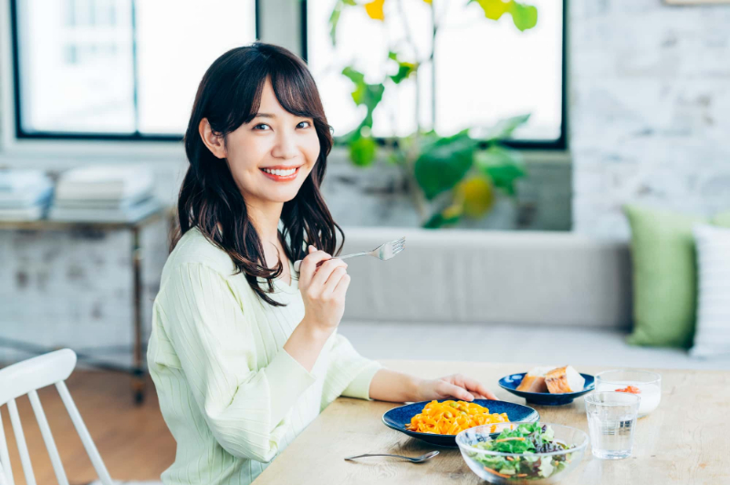 歯と歯の間にできた虫歯を治療して快適に食事をする女性
