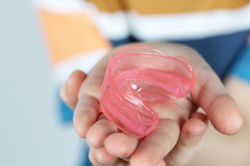 インビザラインファーストのマウスピースを手のひらに乗せている子供
