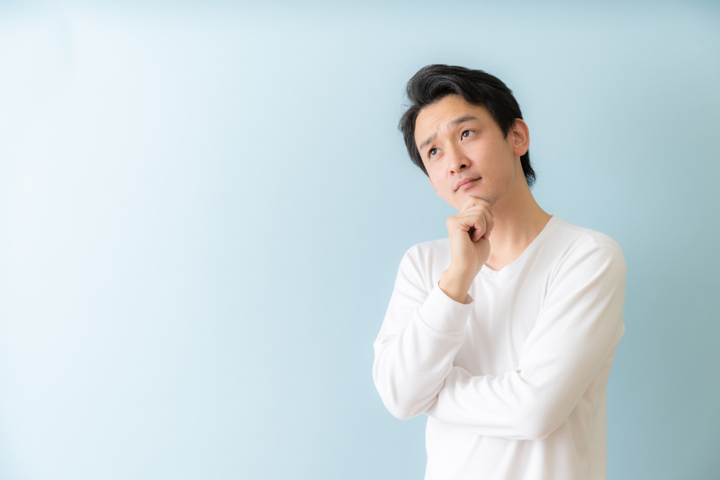 歯周病が原因で歯がぐらつくことがあるのか考える男性