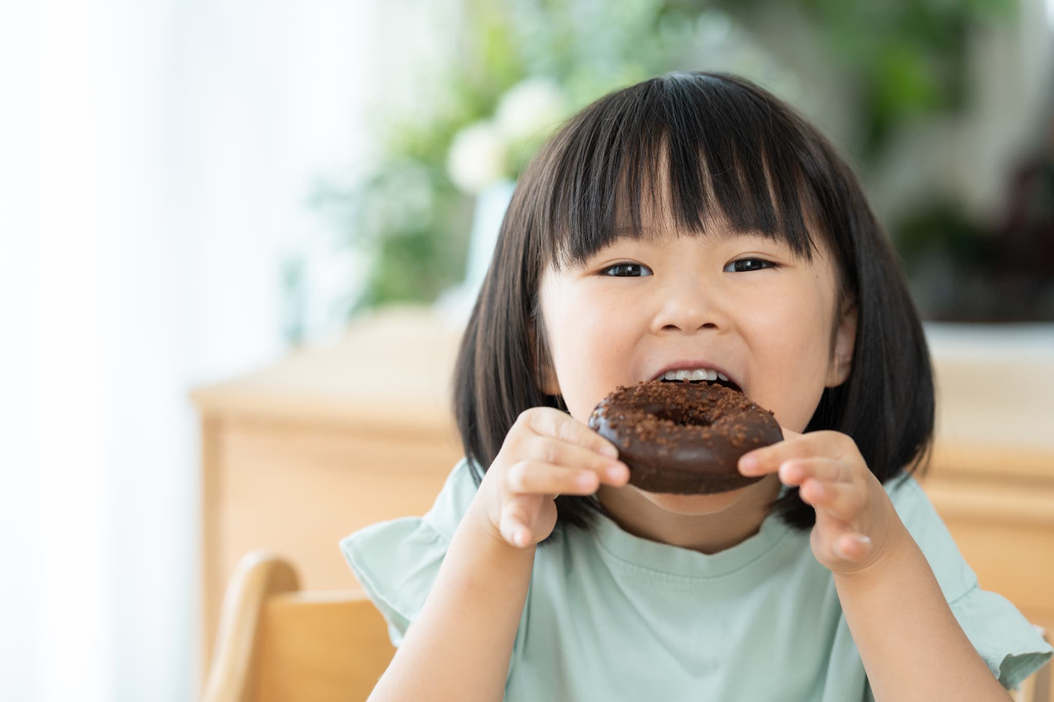 ドーナツにかぶりつく子ども