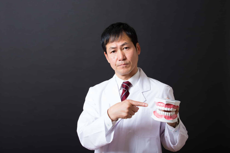 矯正中に虫歯ができた場合の対処法について説明する歯科医