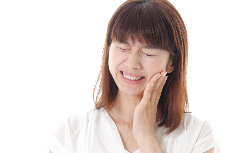 矯正中に虫歯になって痛む女性