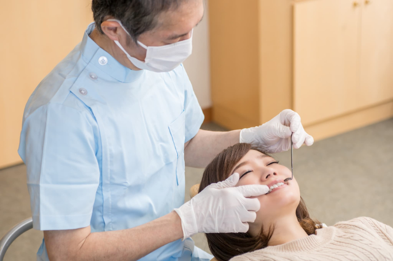 矯正治療後に後戻りして歯医者で診てもらう女性
