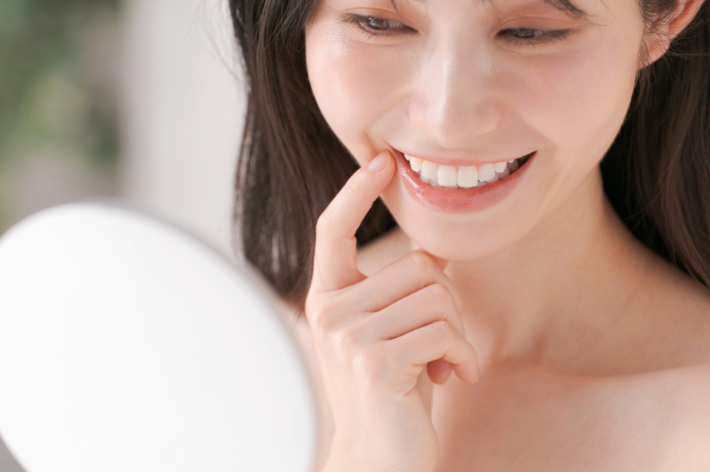 ホワイトニング後に歯の色を確認する女性