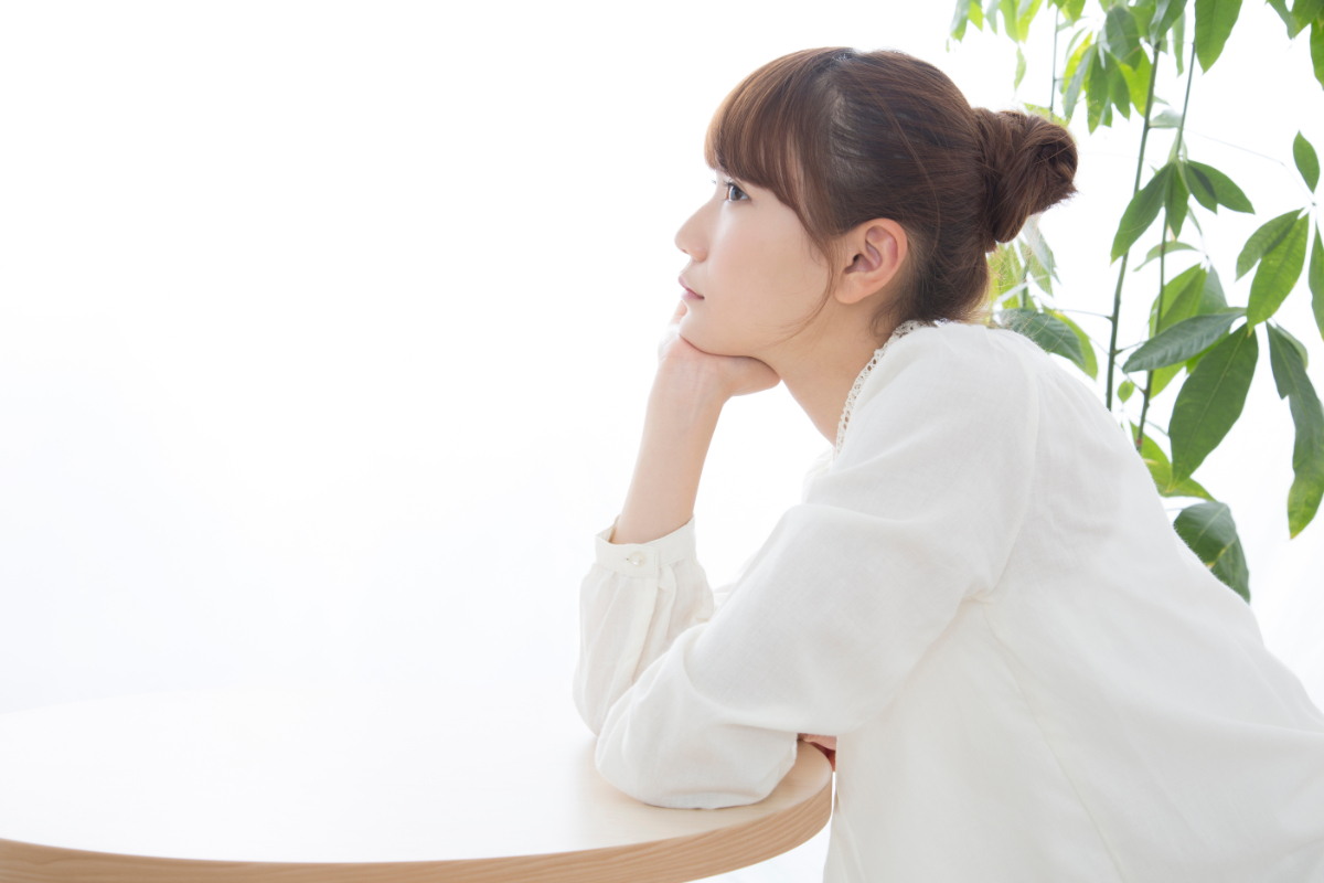 受け口になる原因である頬杖を付いている女性