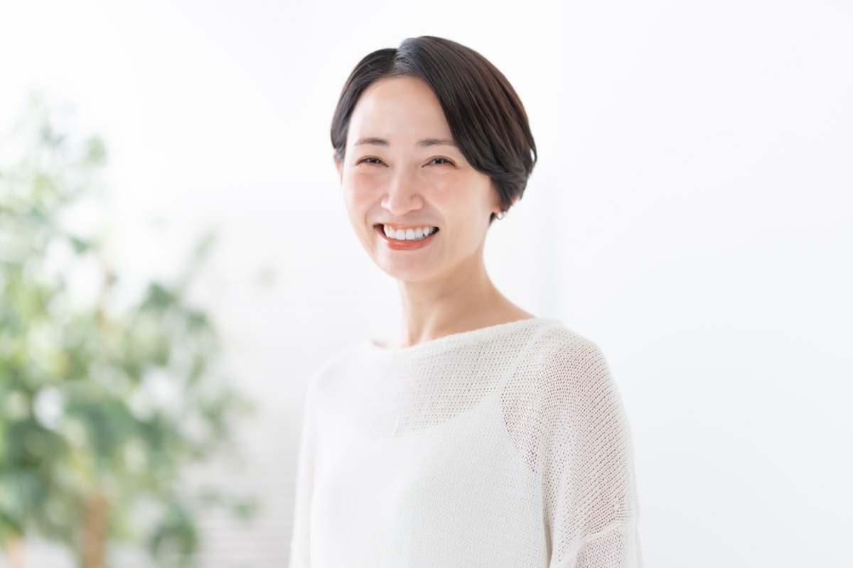 ホワイトニングをした美しい白い歯に満足してほほ笑む女性